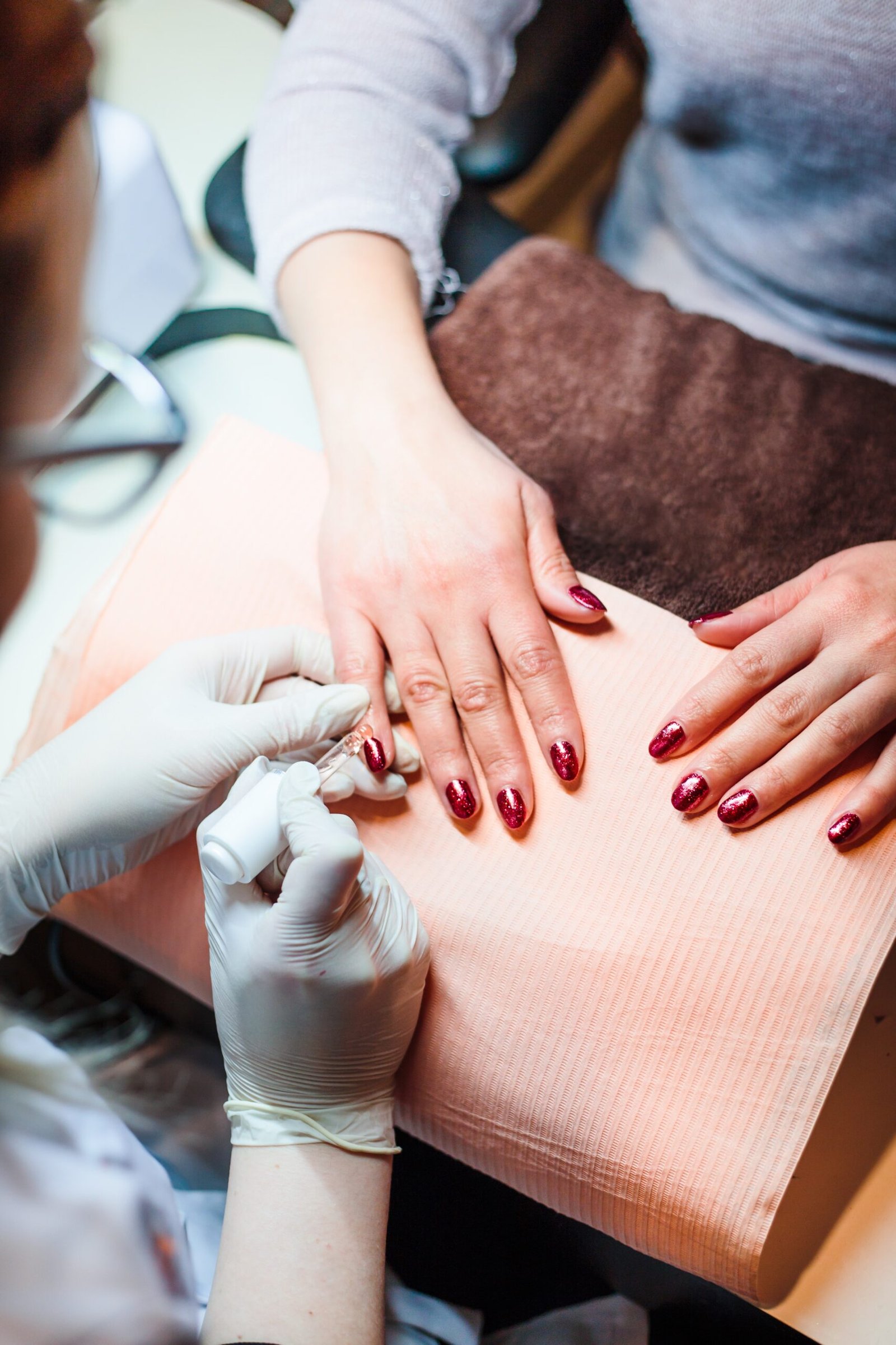 Skilled technician applying nail polish during a Basic Manicure, ensuring a flawless finish and healthy nails at Artysto Salon.