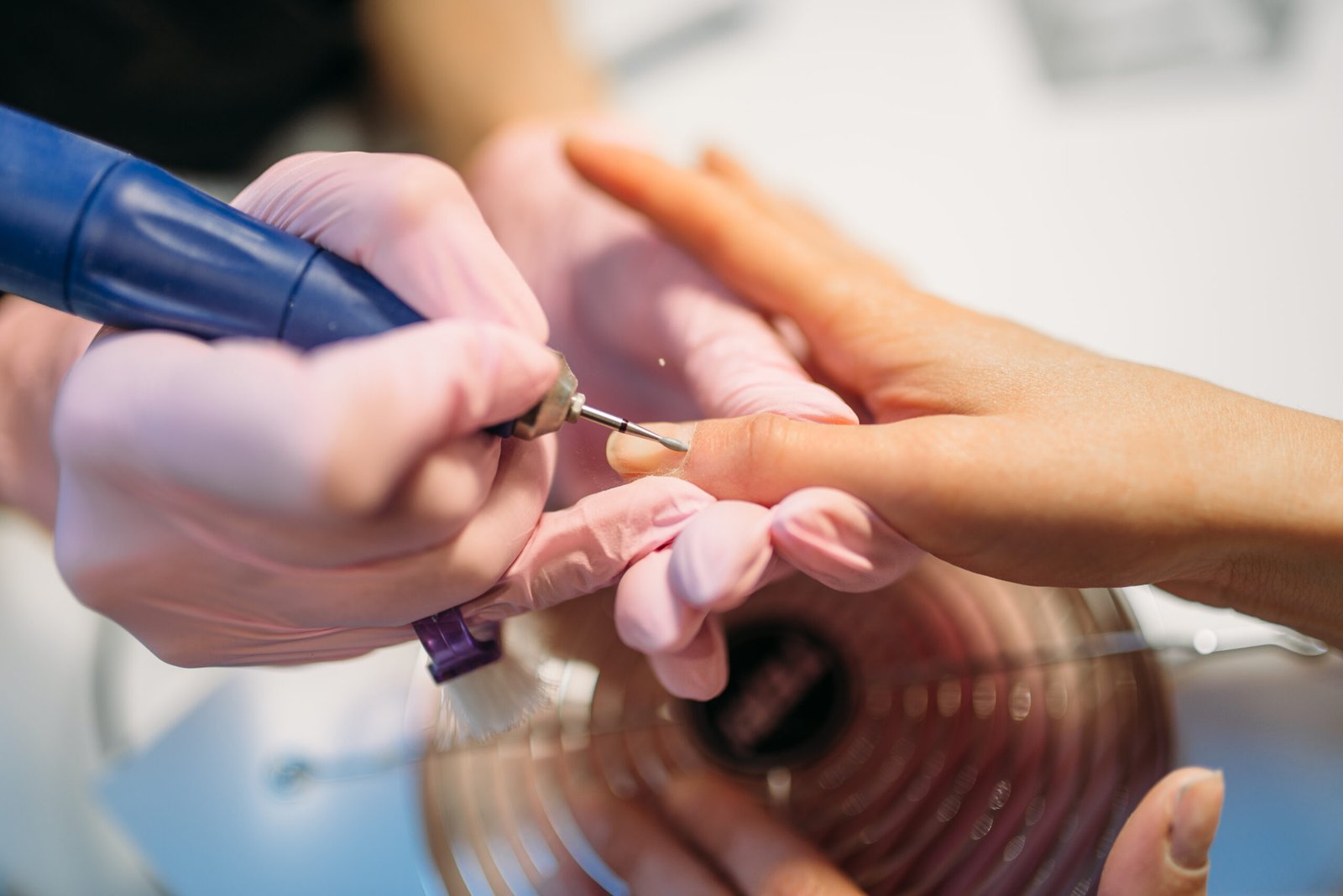 Top-down view of a technician expertly polishing a client's nails for a flawless, high-shine finish during the Signature Manicure.