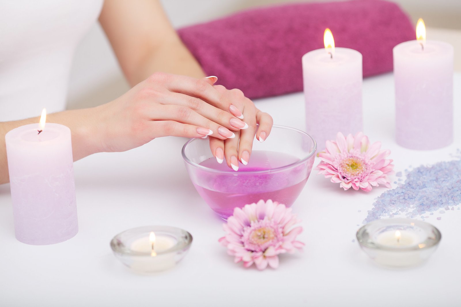 Woman hands receiving a hand scrub peeling by a beautician in beauty salon. SPA manicure, hand massage and body care. Close up, shallow dof.