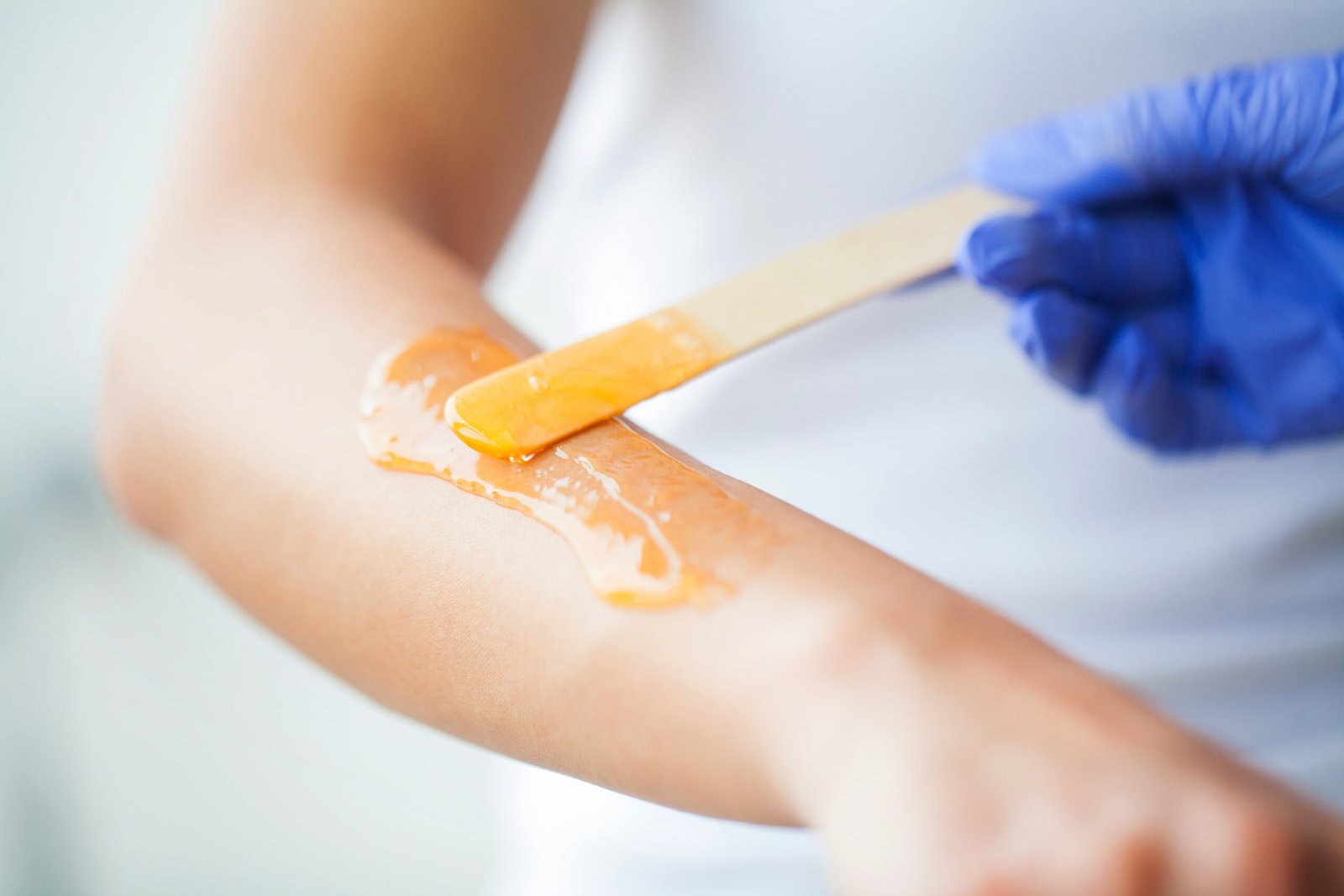 Professional beautician applying wax for ¾ Arms Waxing, achieving soft, smooth, and well-groomed skin.