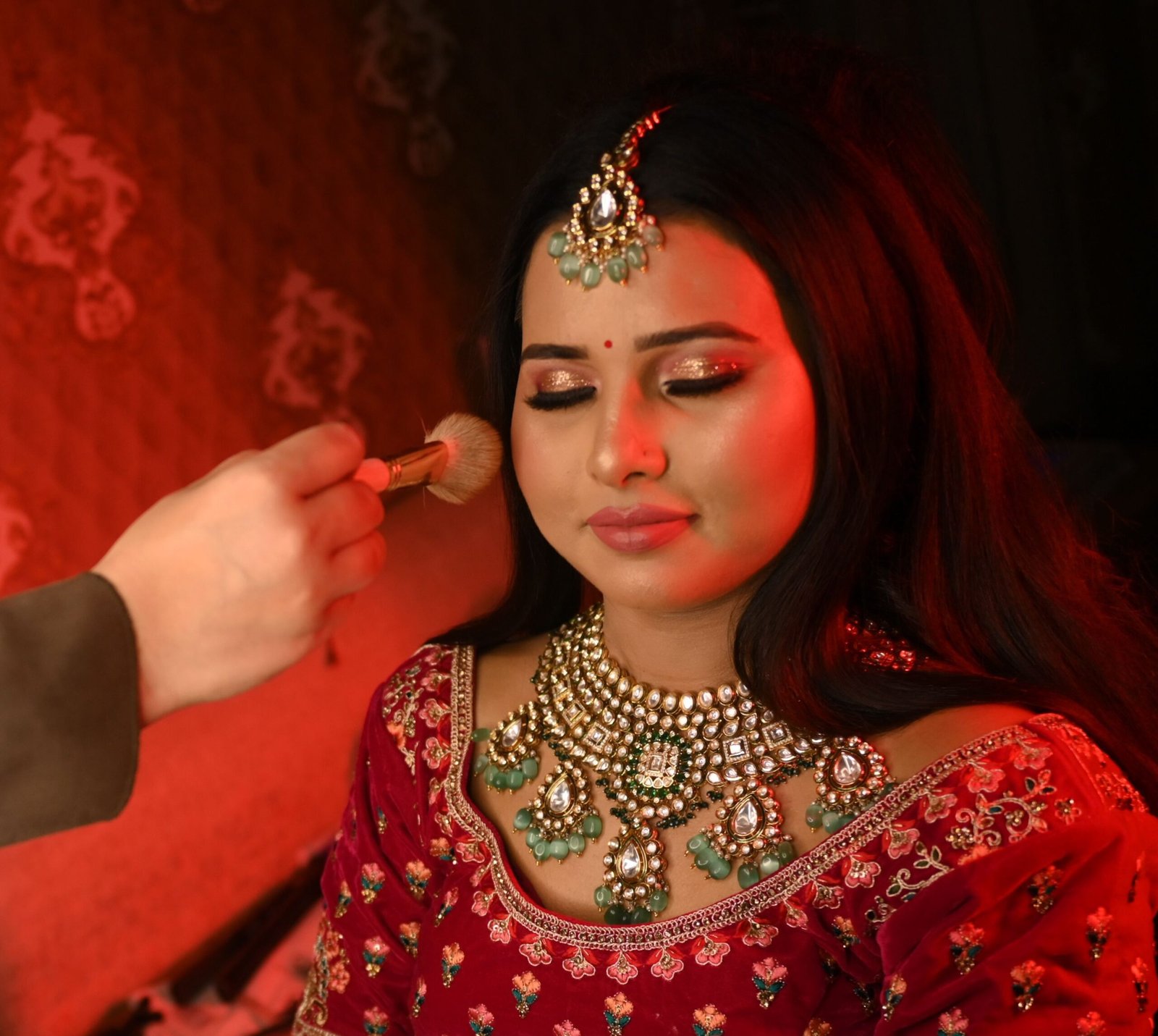 Woman receiving makeup application, traditional attire